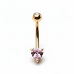 Gold belly button ring with a pink gemstone on a white background